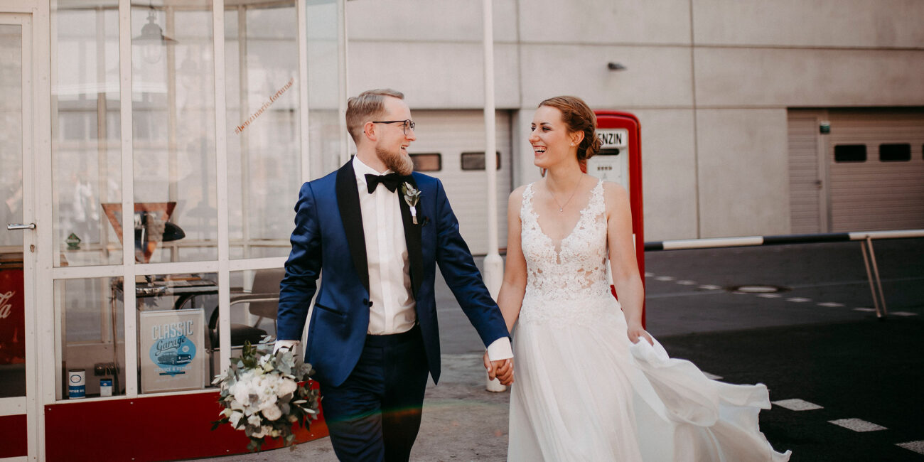 Lachende Braut und Bräutigam Händchen haltend im the Blasky Hotel in Frankfurt.