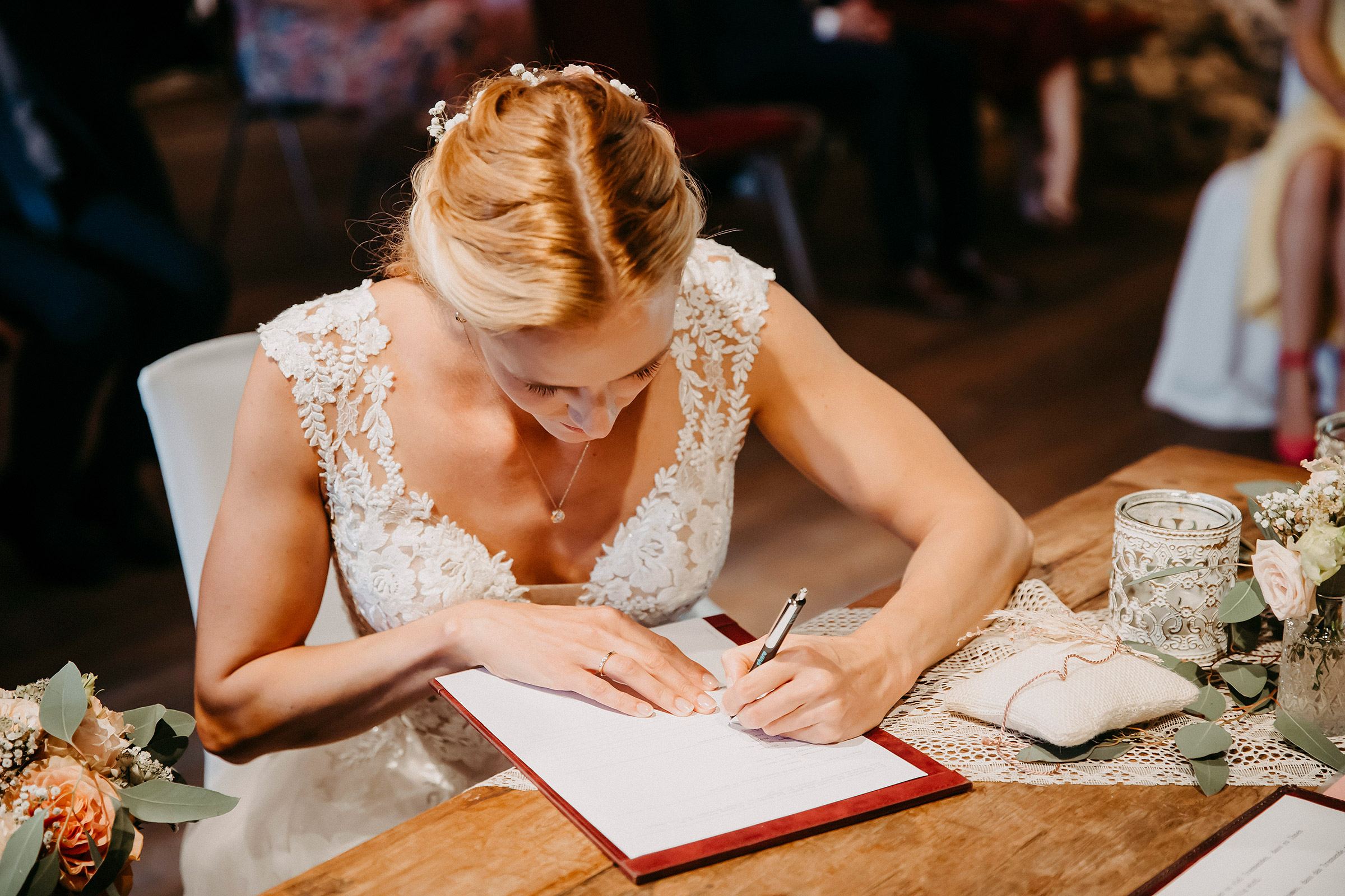 Braut unterschreibt Hochzeitsdokumente an der Zehntscheune im Herrenhof Hanau.